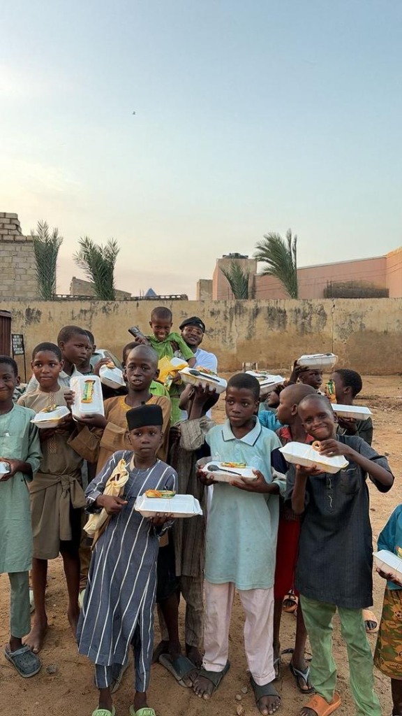Young boys, youths and children happily holding fresh takeout meals during ARF weekly food distribution